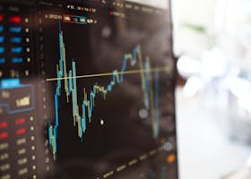Detailed view of financial trading graphs on a monitor, illustrating stock market trends.
